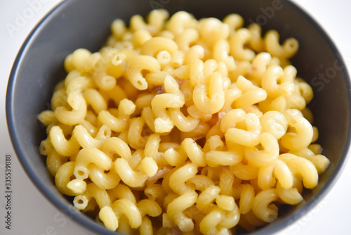 boiled macaroni with meat on a plate on a white background