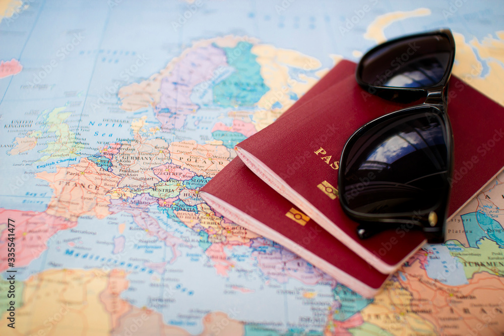 two red passports and sunglasses on the world europe map. travel planning, permission and visa concept