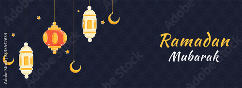 Islamic Holy Month of Ramadan Mubarak Banner with Hanging Colorful Lanterns, Golden Crescent Moon on Blue Textured Background.