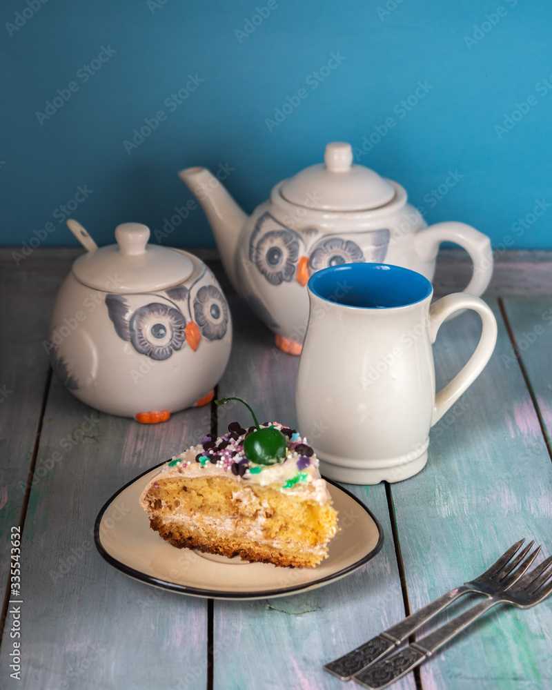 Tea party with homemade cake. Owl-shaped ceramic dishes and vintage forks on a table Tea party with homemade cake. Owl-shaped ceramic dishes and vintage forks on a table