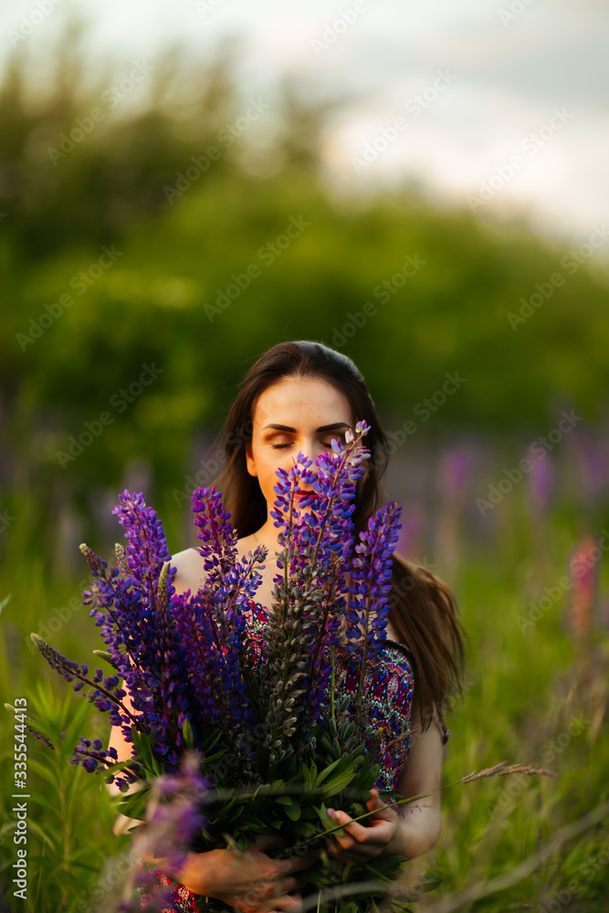 Young girl stand in field overlooking lavender field. Smiling carefree caucasian girl in dress enjoying the sunset Young girl stand in field overlooking lavender field. Smiling carefree caucasian girl in dress enjoying the sunset
