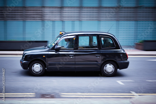 Photography A London cab speeds through a city landscape