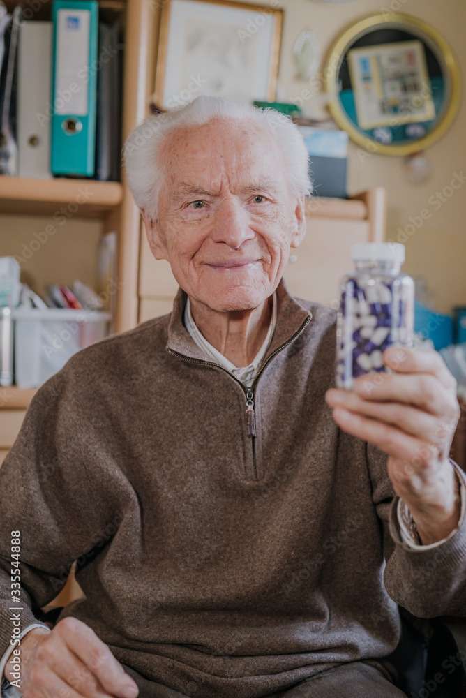Senior man holding bottle with Pills closeup Senior man holding bottle with Pills closeup