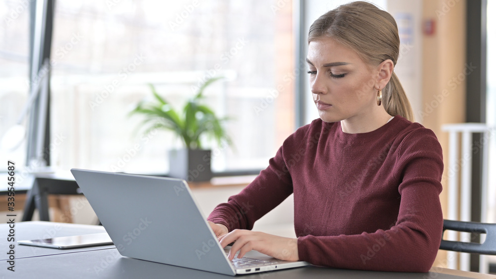 Professional Young Woman using Laptop in Office Professional Young Woman using Laptop in Office