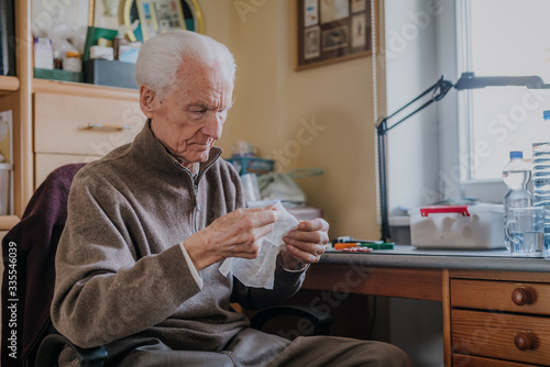 Senior preparing dressing, cuts gauze
