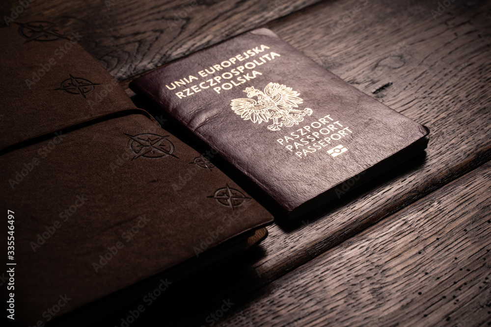 Obraz na płótnie Zdjęcie notesu i paszportu na drewnianym, naturalnym stole w salonie