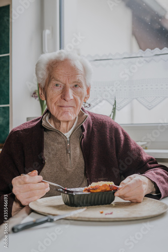 Portrait senior eats dinner at home