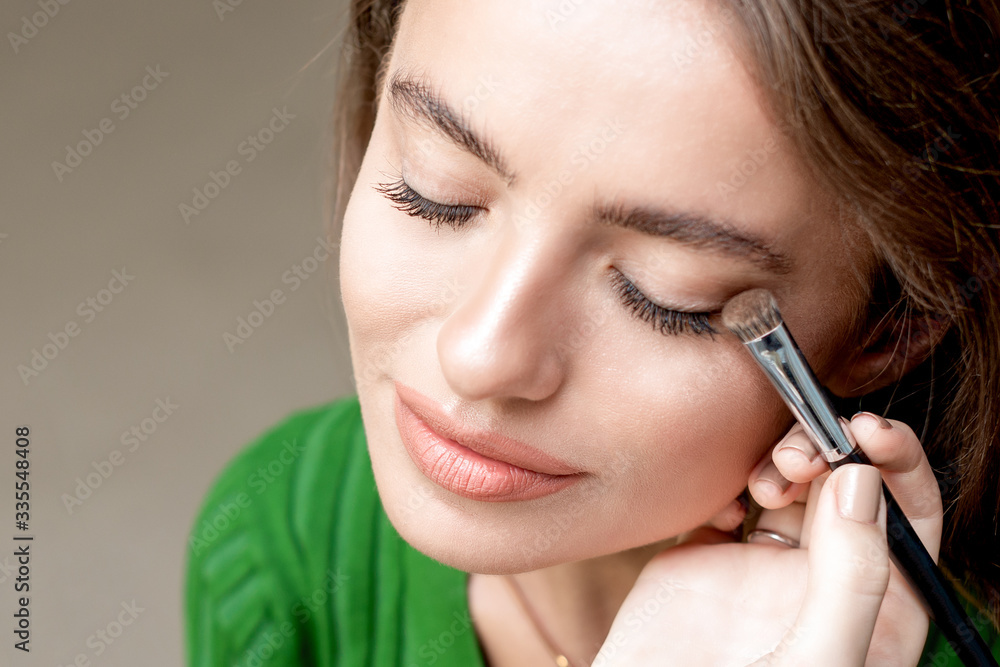 Makeup artist applies eyeshadow.