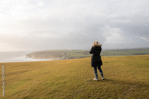 Woman in jacket standing on the cliffs