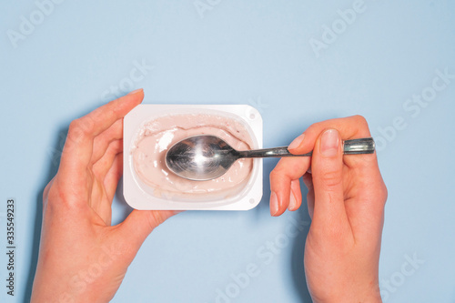 Tableau sur toile A person eats a spoonful of gluten-free vegetarian yogurt with fresh fruits