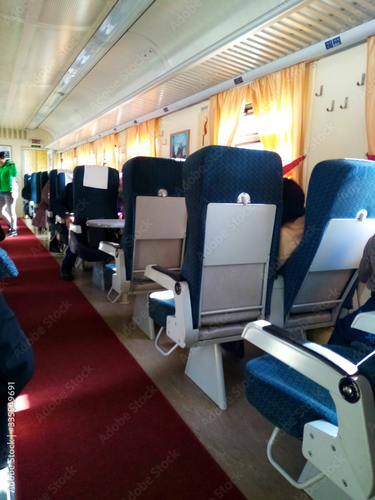 Interior view of the corridor, inside passenger trains with blue fabric seats of the Russian railway system. Interior view of the corridor, inside passenger trains with blue fabric seats of the Russian railway system.