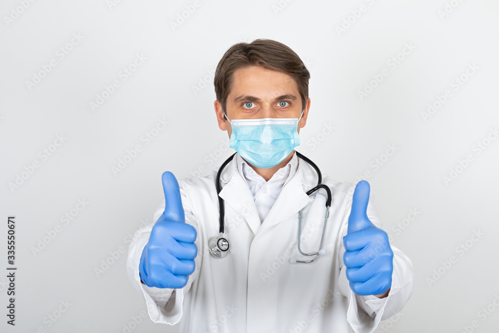 Physician with mask and gloves showing thumbs up Physician with mask and gloves showing thumbs up