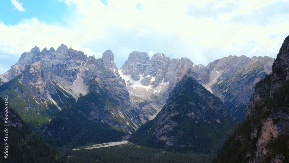Dramatic scenery of high glorious mountain range on clear summer day Spectacular Alps mountain peaks covered by pine forest woods Dramatic scenery of high glorious mountain range on clear summer day Spectacular Alps mountain peaks covered by pine forest woods