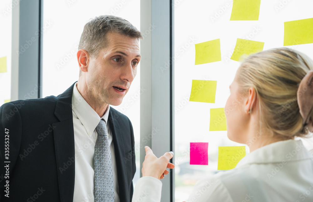 Senior Businessman and businesswoman discussing work in office. Senior Businessman and businesswoman discussing work in office.