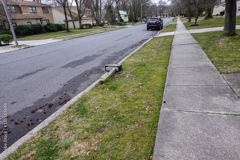 Broken vandalized mailbox post laying on the ground on a suburban street curb Broken vandalized mailbox post laying on the ground on a suburban street curb