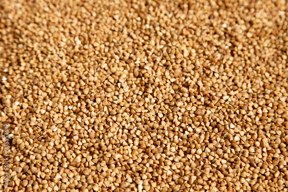 Brown background of buckwheat sprinkled on a table, foreshortening - from above. Concept - stocks before the covid-19 epidemic Brown background of buckwheat sprinkled on a table, foreshortening - from above. Concept - stocks before the covid-19 epidemic