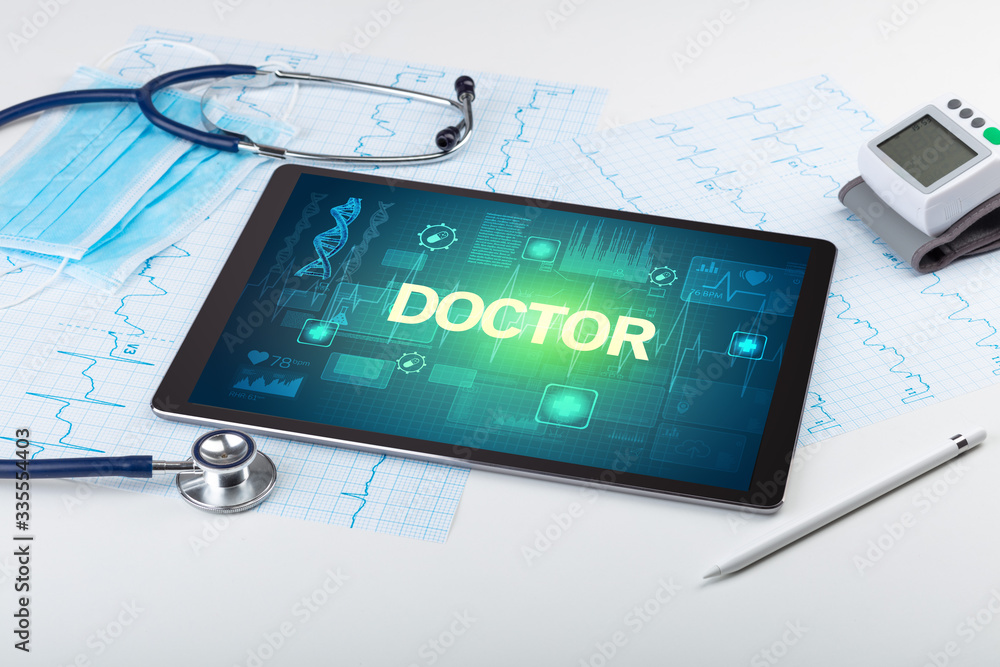 Tablet pc and medical stuff with DOCTOR inscription, prevention concept Tablet pc and medical stuff with DOCTOR inscription, prevention concept
