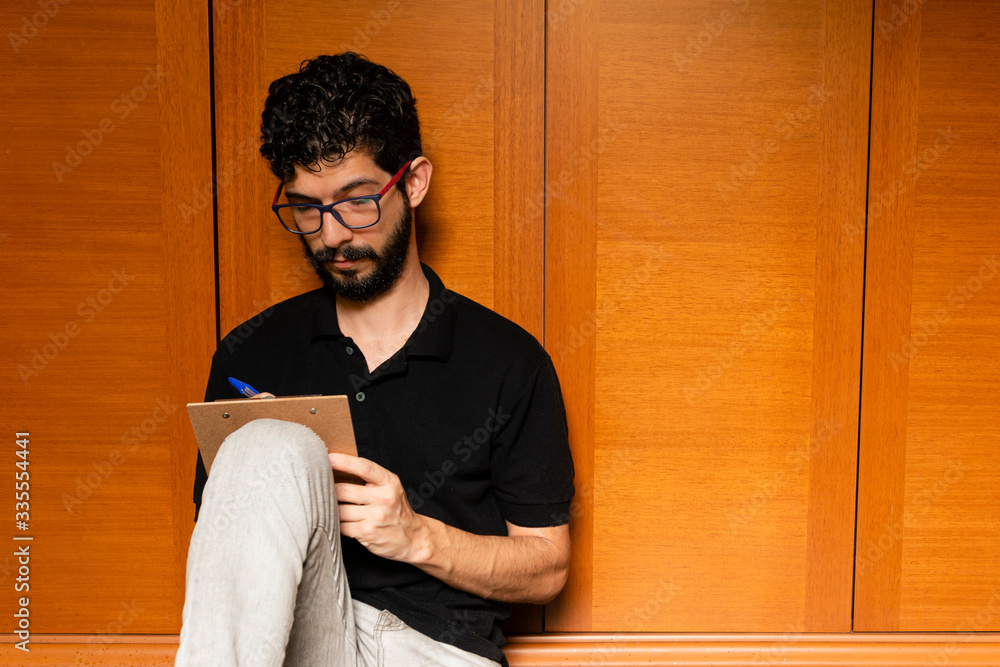 Man taking notes in spreadsheet in his room during quarantine period. Man taking notes in spreadsheet in his room during quarantine period.