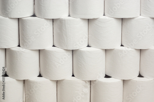 Many rolls of white toilet paper on each other form a wall background photo