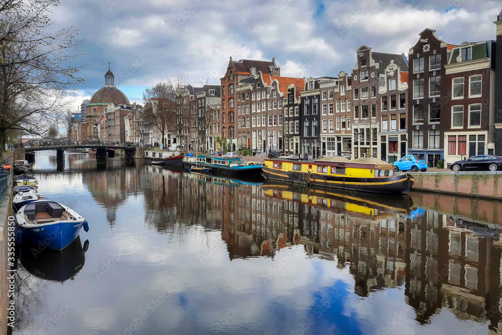 Singel canal in Amsterdam during the intelligent lockdown. No tourists and no boat tours means beautiful reflection in the canals.