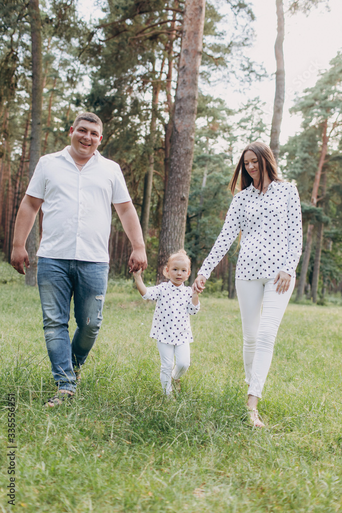 happy Family walking in the park holding hands and smiling. mom, dad and daughter spending time together outdoor on a summer day. selective focus happy Family walking in the park holding hands and smiling. mom, dad and daughter spending time together outdoor on a summer day. selective focus