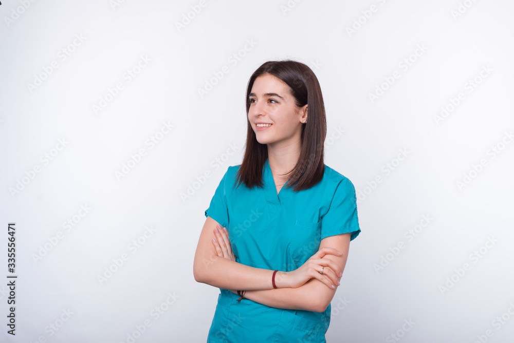 Portrait of young medical female student crossing her arms on white background and looking far. Portrait of young medical female student crossing her arms on white background and looking far.