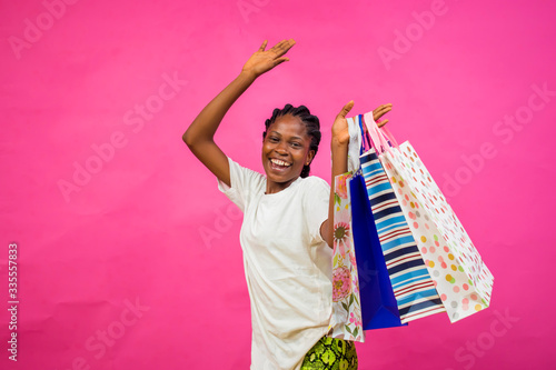 young beautiful black happy lady holding some shopping bags photo