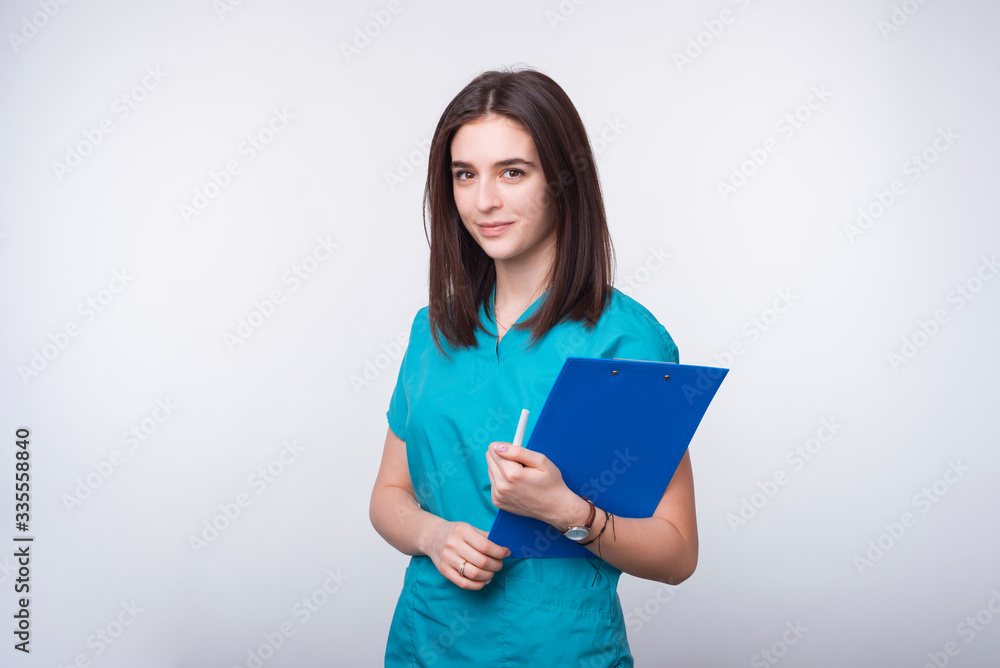 Portrait of a young female doctor or dentist student holding a blue paper board on white background. Portrait of a young female doctor or dentist student holding a blue paper board on white background.