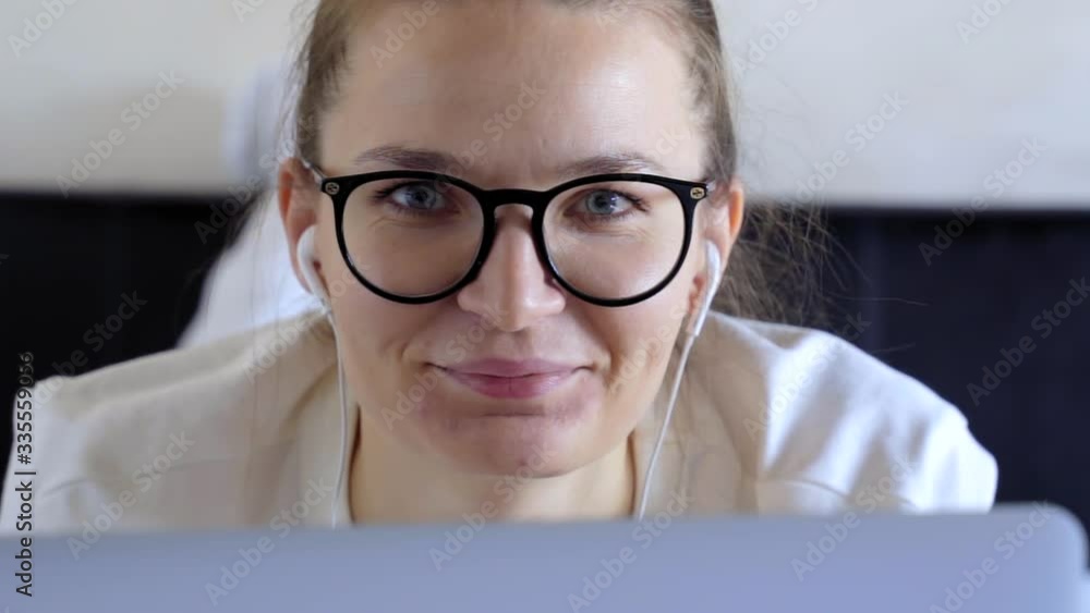 happy young woman in dental braces looking at camera at home office. Front face portrait of girl student in glasses and headphones smiling working on laptop. People front portrait. Online tutoring. happy young woman in dental braces looking at camera at home office. Front face portrait of girl student in glasses and headphones smiling working on laptop. People front portrait. Online tutoring.