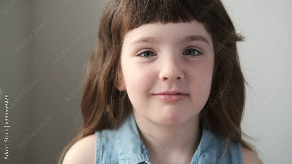 A 6-7 year old girl opens her eyes and laughs. Close up. A 6-7 year old girl opens her eyes and laughs. Close up.