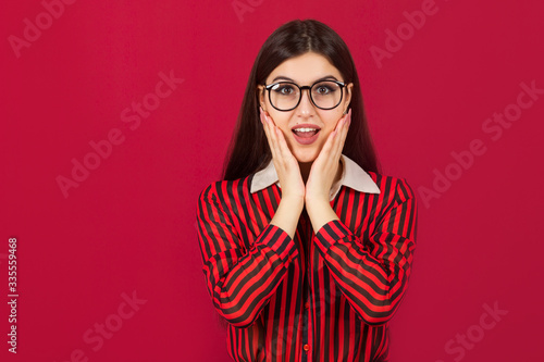 beautiful young woman in a shirt with glasses on a red background