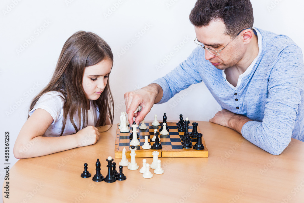 Girl and dad play a game at home, chess, puzzle for brain development, mental intelligence, child development, school, home, quarantine, vacation, time with family Girl and dad play a game at home, chess, puzzle for brain development, mental intelligence, child development, school, home, quarantine, vacation, time with family