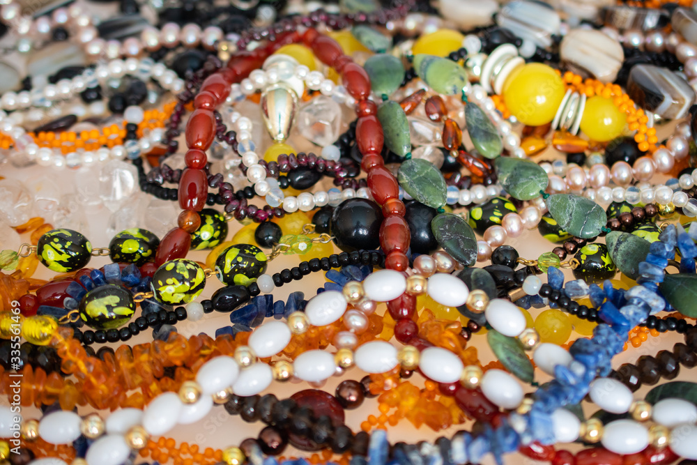 A lot of natural stone jewelry: quartz, rock crystal, amber, pearls, opal, carnelian, garnet, sodalite, agate-texture, background, luxury, fashion concept