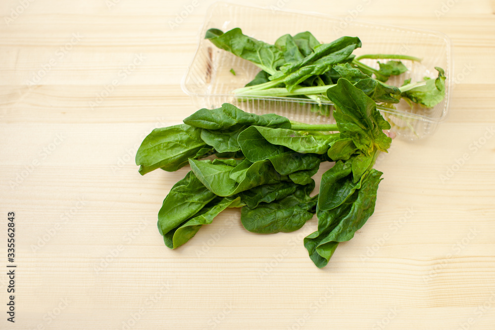 Fresh spinach leaves on a wooden background Fresh spinach leaves on a wooden background