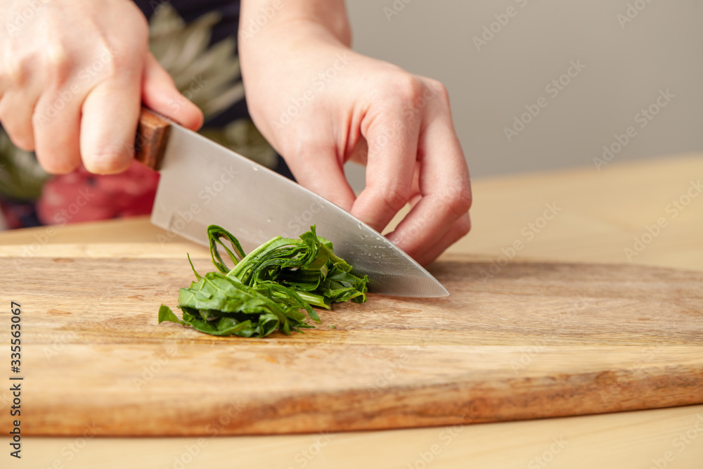 Cooking spinach leaves on a cutting Board in the kitchen. Cooking spinach leaves on a cutting Board in the kitchen.