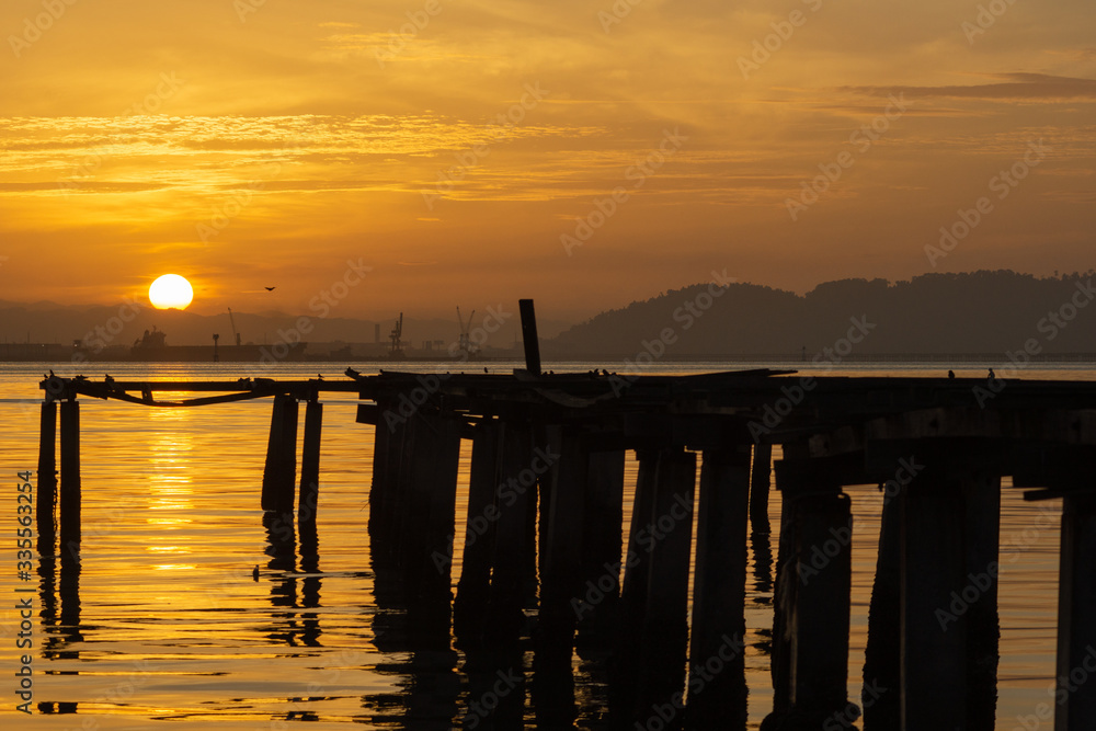 Beautiful sunrise over the sea near the wooden Bridge at fisherman jetty Penang, Malaysia.