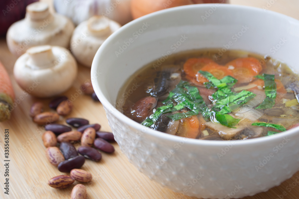 Healthy vegetable and bean soup with its ingredients: carrots, mushrooms, onions, garlic, herbs and kidney beans Healthy vegetable and bean soup with its ingredients: carrots, mushrooms, onions, garlic, herbs and kidney beans