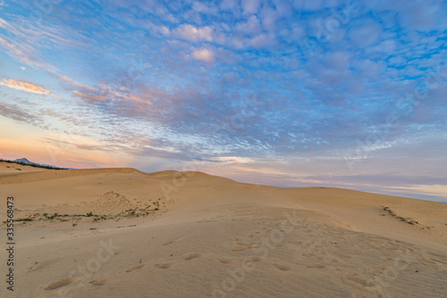 Landscape photo of sand dune under blue sky at sunset