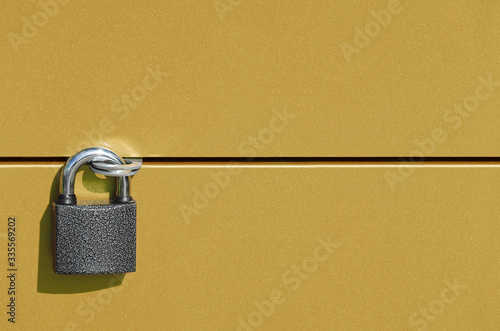 two horizontal metal doors are securely connected by a strong padlock