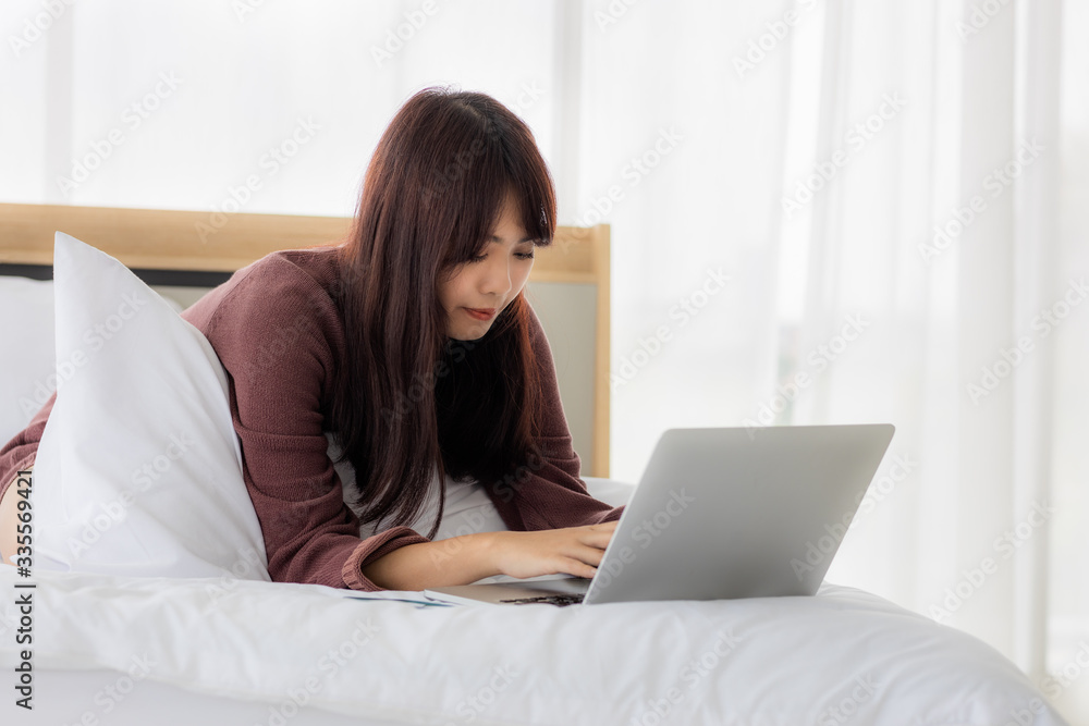 Asian woman using laptop for working, educational, e-commerce, social media in her bed. corovavirus covid-19, stay at home, work form home concept. Asian woman using laptop for working, educational, e-commerce, social media in her bed. corovavirus covid-19, stay at home, work form home concept.