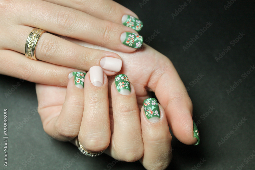 Beautiful moon manicure gel Polish on natural nails with flower design gel Polish drawn by hand on the hands of a young woman Beautiful moon manicure gel Polish on natural nails with flower design gel Polish drawn by hand on the hands of a young woman