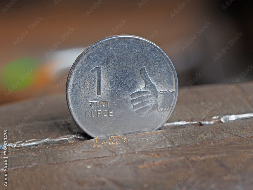 Indian rupee coin clamped in a metal vise on both sides. The concept of financial pressure on the currency business Indian rupee coin clamped in a metal vise on both sides. The concept of financial pressure on the currency business