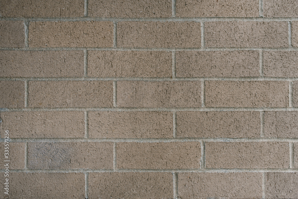 Fototapeta premium Beautiful smooth brick wall of gray-beige color. Copy space background