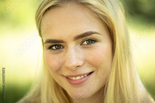 Close-up of Female Face, smiling blond Girl In Nature