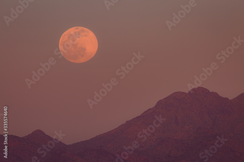  waiting for and then seeing a full moon rise from behind a colorful desert mountain with its thin brightness and perfection is a great past time. This Snow Moon rises in the Phoenix, Arizona area