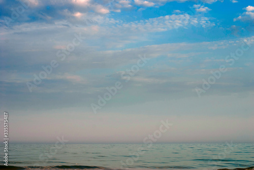 Blue sea surface extending to the horizon under a cloudy sky.