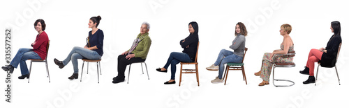 Bild auf Leinwand group of women sitting on chair on white background, side view