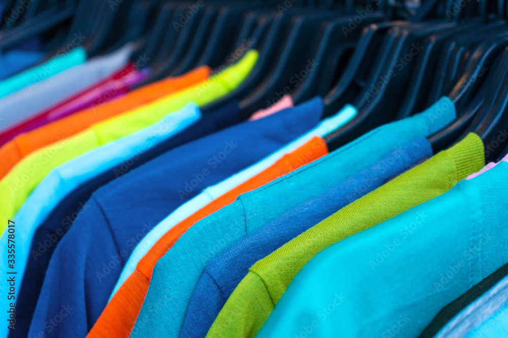 Multi-colored t-shirts on a hanger. Clothing store Multi-colored t-shirts on a hanger. Clothing store