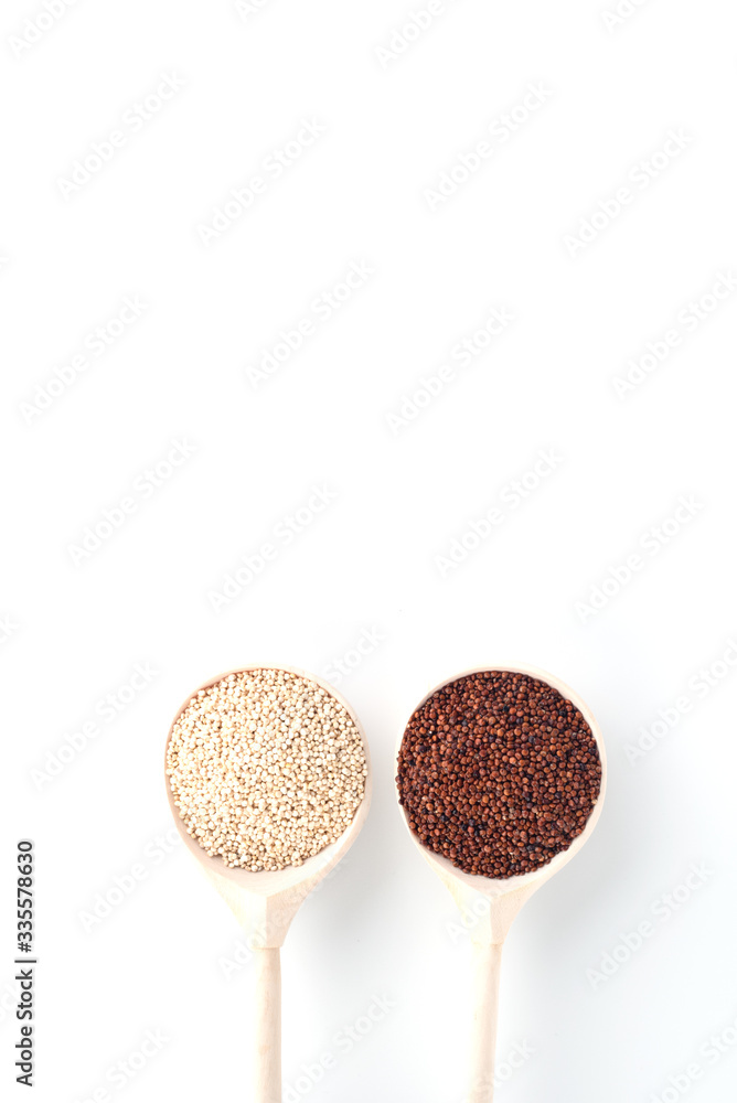 in wooden spoons on a white background are the seeds of white and red quinoa in wooden spoons on a white background are the seeds of white and red quinoa