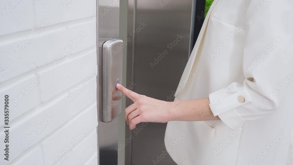 business lady calls the Elevator in the lobby of the business center. business lady calls the Elevator in the lobby of the business center.